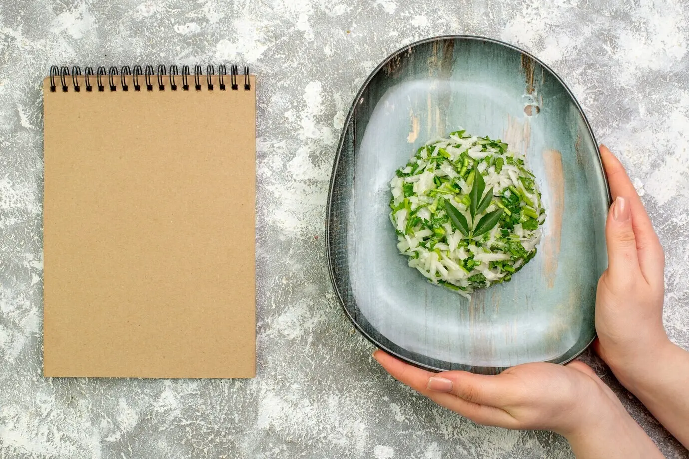 Вид сверху на аппетитный салат из зелени и капусты в тарелке.